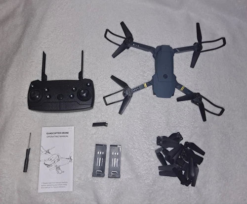 Quadcopter drone kit with controller, spare propeller blades, batteries, and user manual