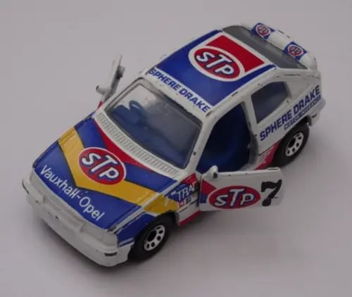 Diecast racing car model with white, blue, and red STP graphics and open windows