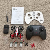 Black drone controller with hand grip, instruction sheet, and multirotor parts