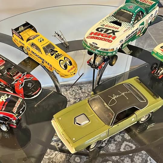 Diecast funny car lot with yellow, green, black, and red cars on display