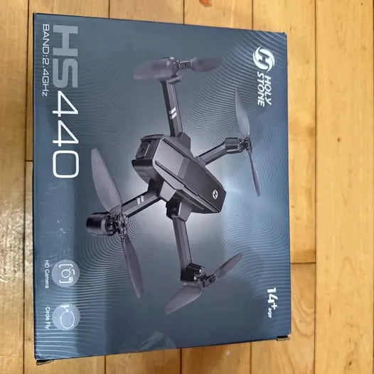 Black foldable quadcopter drone with four propellers on product box