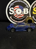 Blue Hot Wheels 1:64 diecast car with black wheels, front 3/4 view.