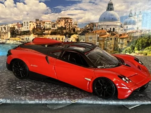 Red diecast sports car model with black wheels and dark tinted windows
