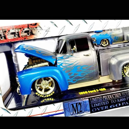 Blue and silver diecast 1955 Ford F-100 truck with detailed wheels, on display base