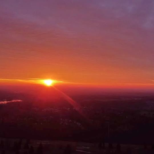 Sunset landscape view with glowing horizon and city lights in the distance