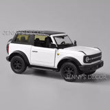 White Ford Bronco diecast pull-back model car, black wheels and roof, front three-quarter view