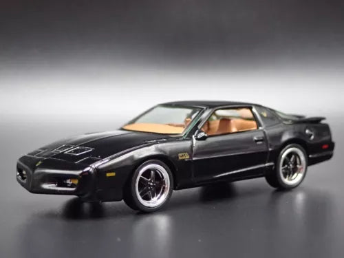 Black 1:64 scale diecast model car with tan interior, front 3/4 view