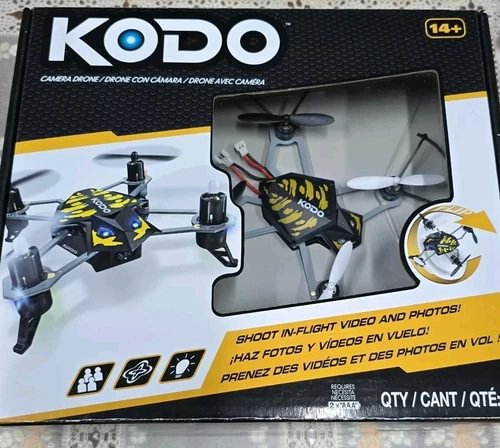 KODO camera drone in open box packaging with accessories, propellers visible