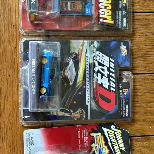 Vintage diecast car blister pack showing blue and black cars with decals