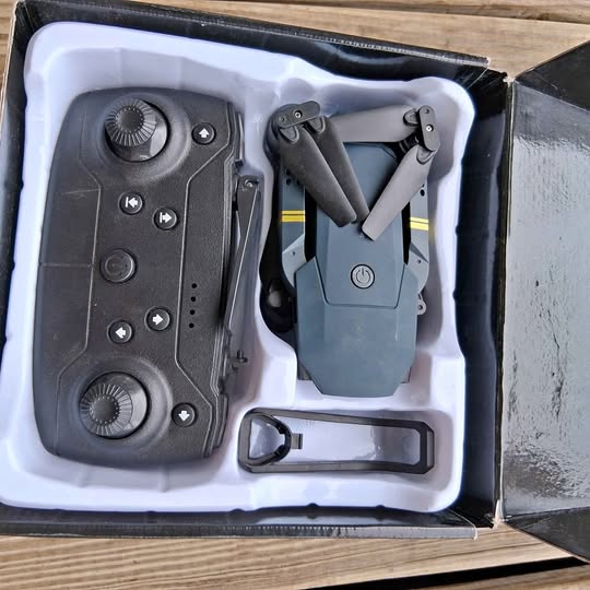 Drone kit in box with remote controller and folded drone, components in foam insert