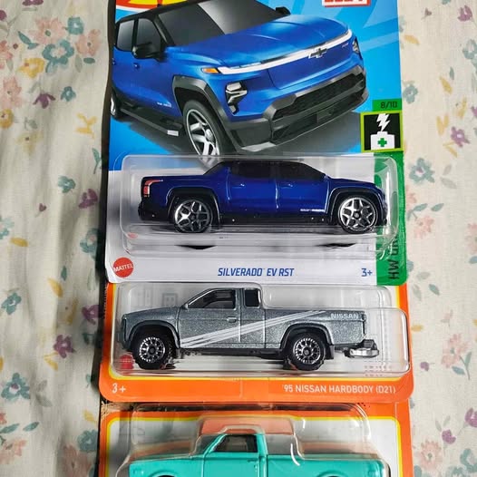 Diecast vehicle blister pack with blue SUV, silver truck, and teal pickup