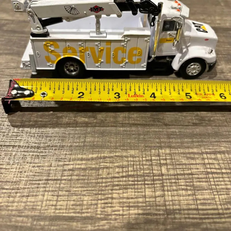 White diecast service truck model with raised boom and CAT-style graphics