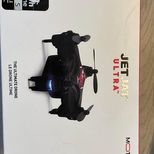 Black quadcopter drone with four arms, side view