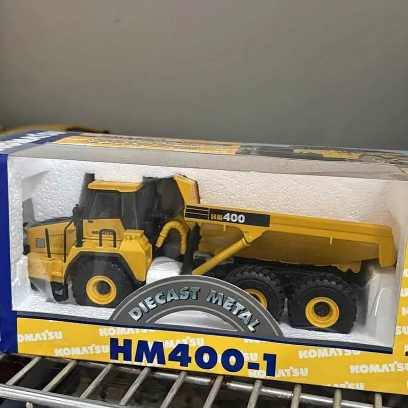 Diecast metal yellow dump truck with black cab, in display box, front view