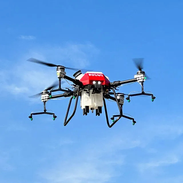 Agricultural spraying drone with red centrifugal nozzle housing and four spray arms