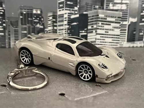 Pearl white diecast model car keychain with keyring, sleek low-profile body and wheels.