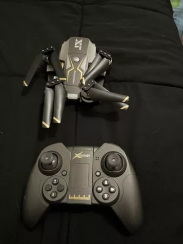 Toy camera drone with handheld controller, gray and black quadcopter with lights