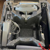 Light gray quadcopter drone in case with controller, cables, and battery