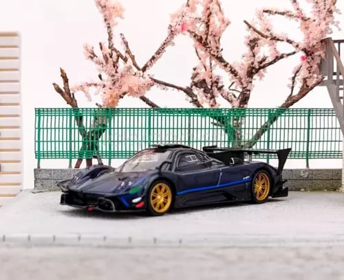 Blue and black diecast sports car model with gold wheels, low front view