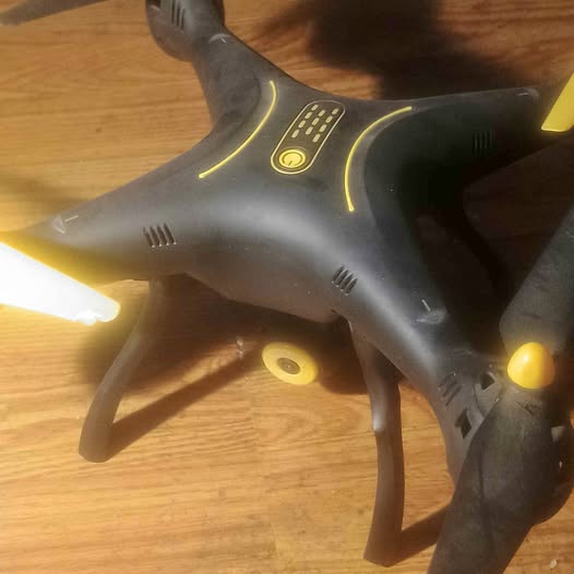 Black and gray drone with yellow LED lights, close front view