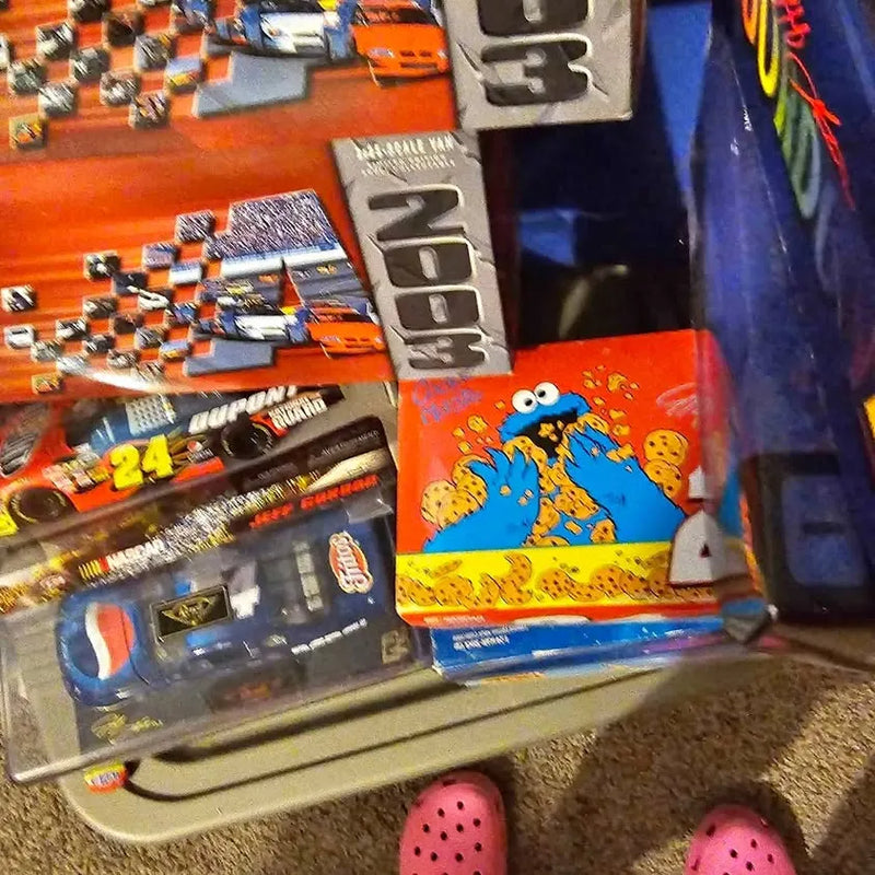 Diecast car toy package with orange and blue graphics, checkered race car art