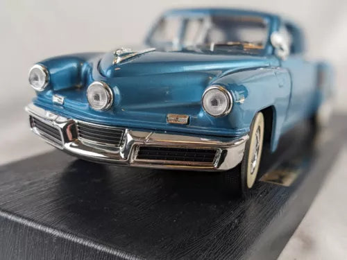 Blue 1:18 diecast car model with chrome grille and front lights