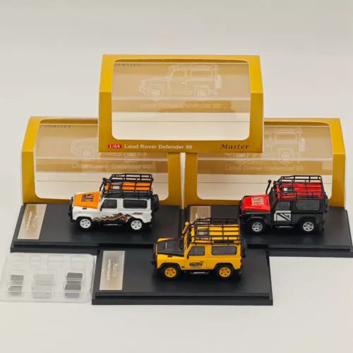 1:64 diecast Defender 90 toy set: camel, white, red trucks in display case