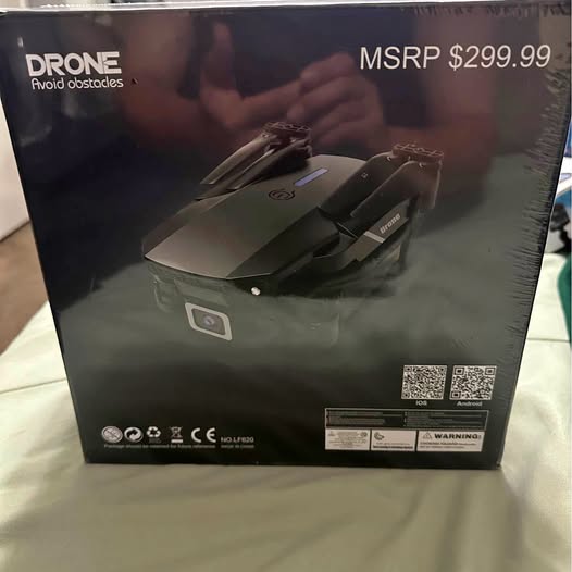 Mini drone in retail box, with folded rotors and instruction labels