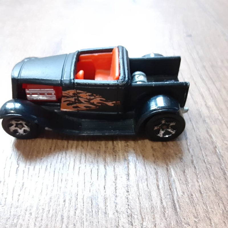 Hot Wheels diecast car, black with orange interior and flame graphics