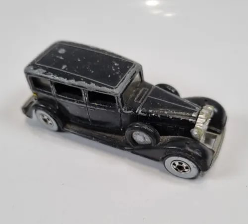 Black Hot Wheels diecast car, classic sedan body with chrome details and wheels