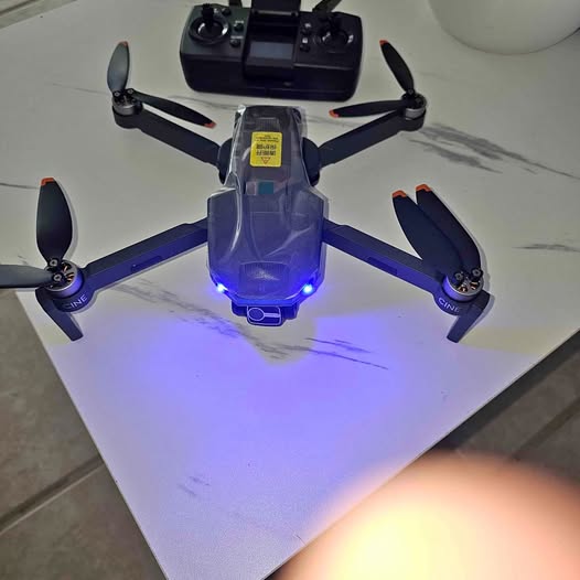 Quadcopter drone with blue LED on body and four propellers