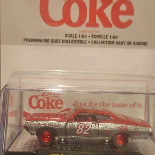 Diecast race car with red hood, gray body, and number 82 in clear box