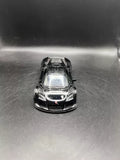 Black diecast toy race car, front view, open wheels detail, 1:36 scale