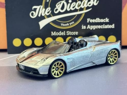 Silver die-cast sports car with yellow wheel rims, open-top design