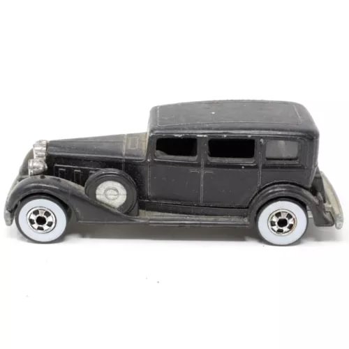 Vintage diecast toy car, dark gray body with silver wheels, side view