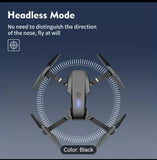 Black foldable quadcopter drone, front view with four propellers and LED.