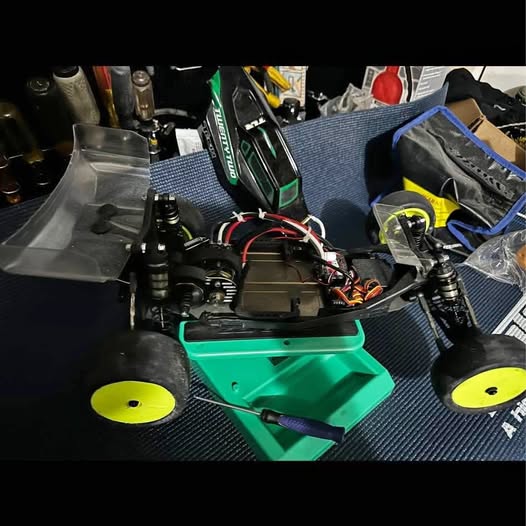 Green and black quadcopter drone with four propellers and exposed landing gear
