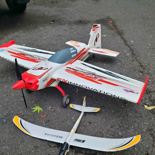 RC drone aircraft with white and red body, front propeller and fixed landing gear