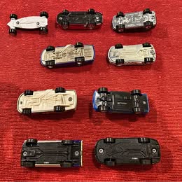 Assorted diecast toy cars in various colors and styles, top and side views.