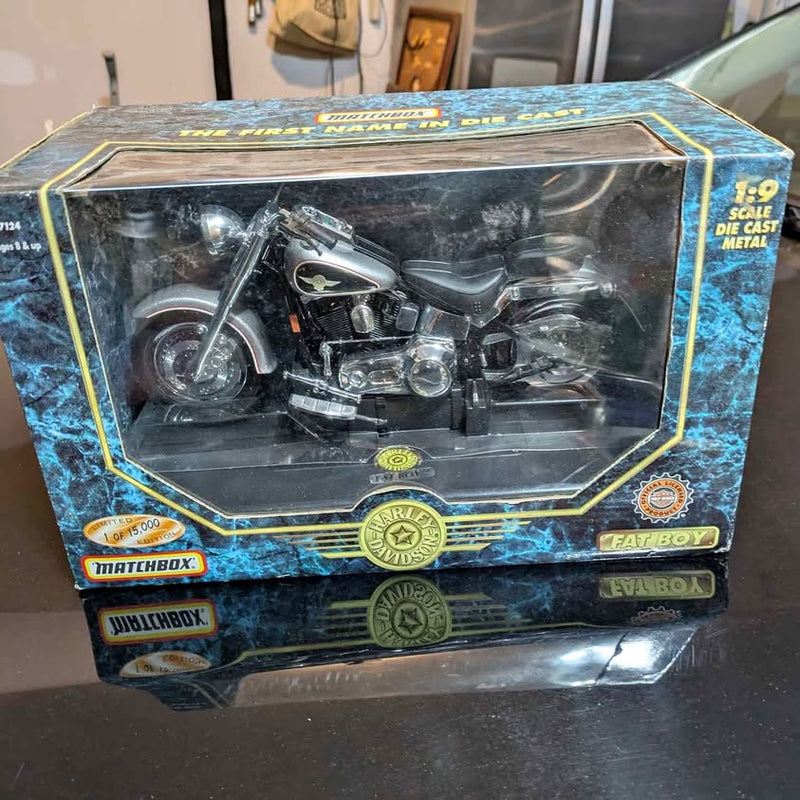Diecast motorcycle model in clear display box, blue with yellow trim, Harley-style bike