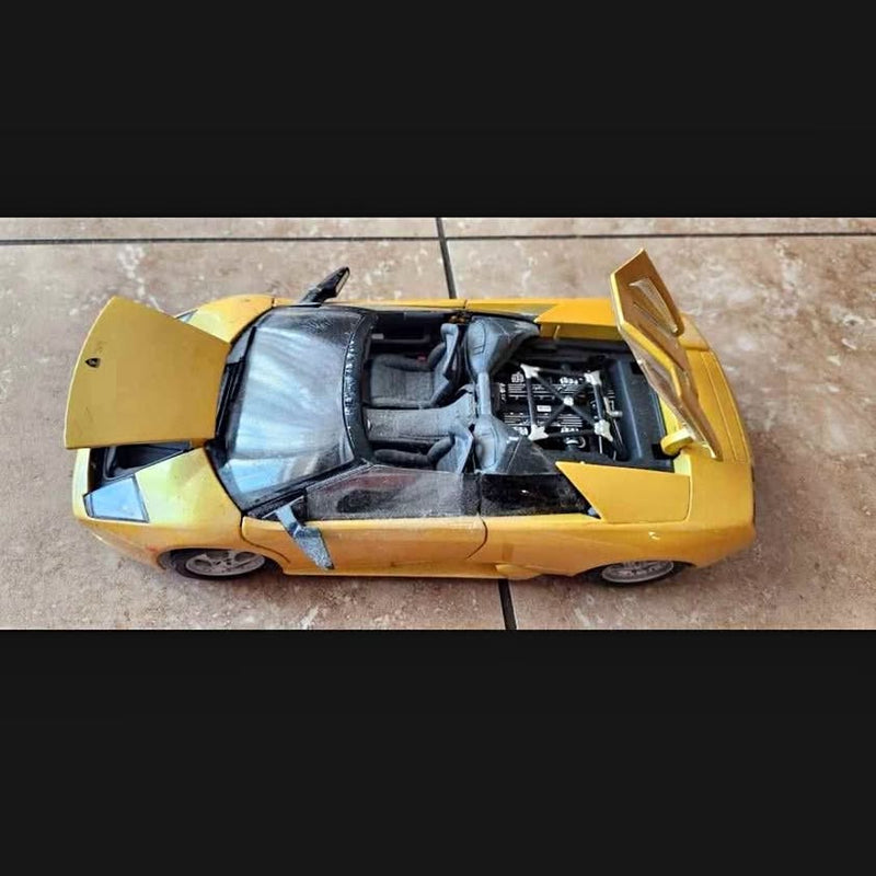 Ferrari diecast sports car in yellow/gold with doors open, exposed interior