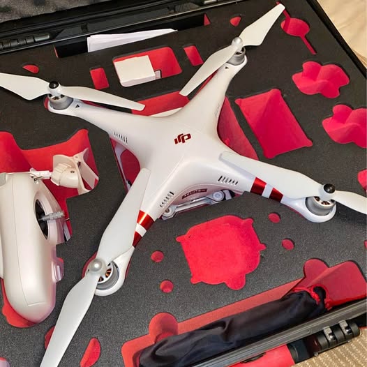 White quadcopter drone with red accents in black HPRC case, propellers visible