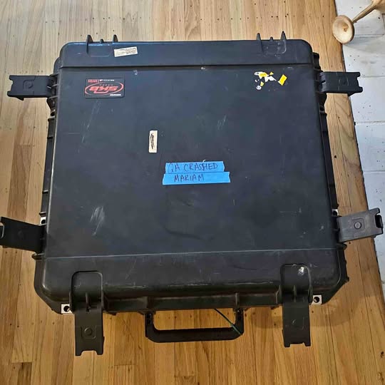 Black hard-shell drone carrying case with handle and metal latches