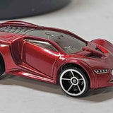 Red diecast toy car with black details and silver wheels, close-up front view