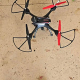 Quadcopter drone with red-tipped propellers, compact black body