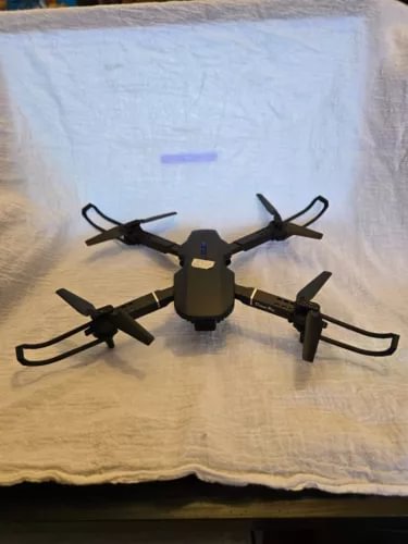 Black quadcopter drone with four propellers and central camera body