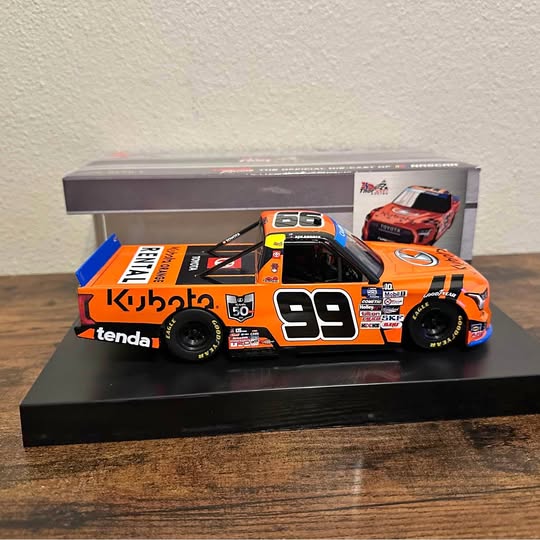 Orange and black diecast race truck model with number 99 and Kubota branding