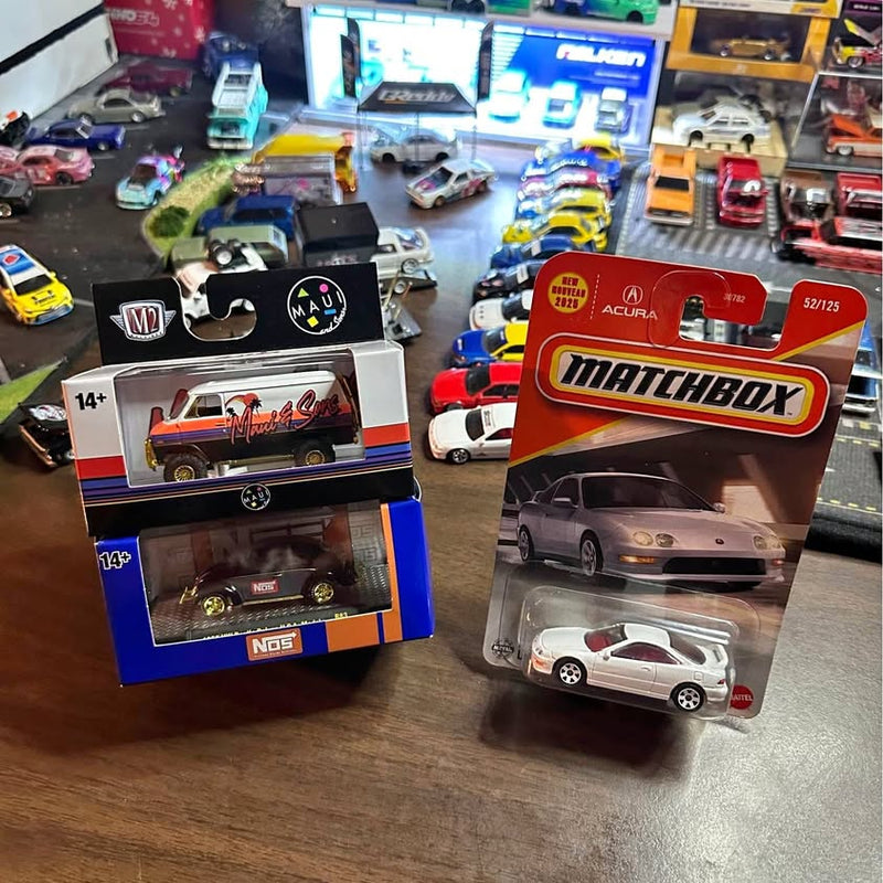 Diecast toy car in clear blister packaging, gray car with red Matchbox box
