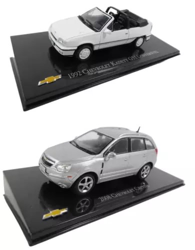 Set of 2 diecast model cars, silver and white, on black display bases