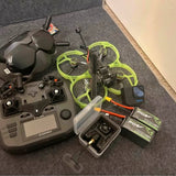 Quadcopter drone with neon green prop guards and remote controller